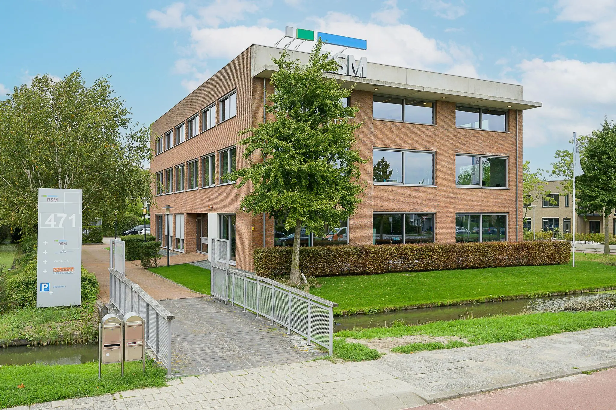 Kantoorpand van RSM aan de Jacques Dutilhweg met een bruggetje over een sloot en duidelijk zichtbaar huisnummer 471.